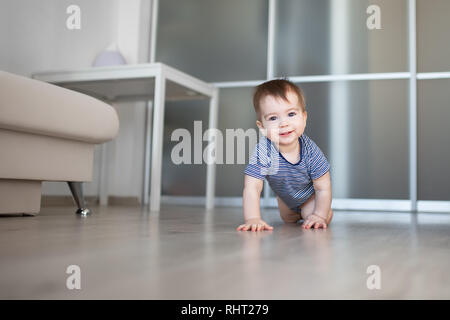 Happy Baby Boy zu Hause kriechen auf dem Boden Stockfoto