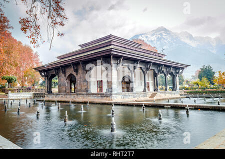 Mughal Erbe Gebäude mit Schnee bedeckten Bergen Zabarwan im Hintergrund, während Sie im Herbst in Shalimar Bagh Garten von Kaschmir Stockfoto