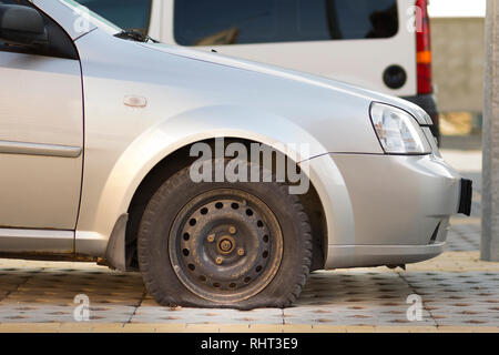 Reifen von Auto auf dem Bürgersteig. Seitenansicht im Außenbereich des Fahrzeugs schließen. Transport problem-, Unfall- und Krankenversicherung Konzept. Stockfoto