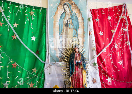 RIO LAGARTOS, MEXIKO - 14. Februar: Statue der Jungfrau Maria vor der Mexikanischen Flagge in einem Busbahnhof in Rio Lagartos, Mexiko am 14. Februar 2017 Stockfoto