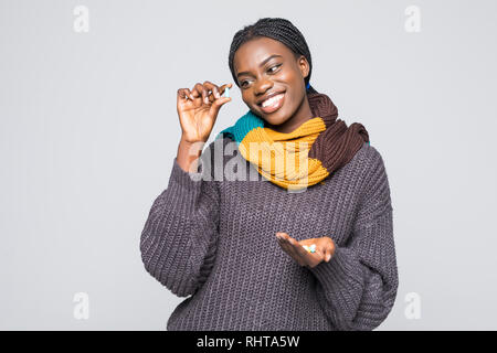 Lächelnd afrikanische Frau im grauen pullover, Schal halten Medikamente Aspirin Tabletten, Pillen auf grauem Hintergrund. Stockfoto