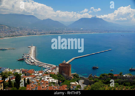 Blick auf die Mittelmeer küste in der türkischen Stadt Alanya mit nebligen Berge unter cumulus Wolken am Horizont und die berühmten Roten Turm auf der Stockfoto