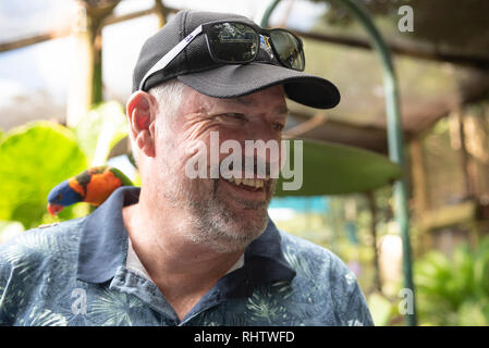 Mann mit Rainbow lorrikeet, Knockrow, New South Wales, Australien Stockfoto