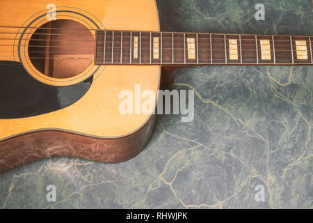 Akustische Gitarre auf grünem Marmor Hintergrund, Musik Konzept. Stockfoto