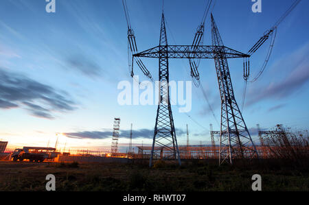 Übertragung der Strommast Silhouette gegen blauen Himmel in der Abenddämmerung Stockfoto