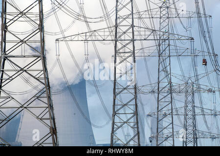 04. Februar 2019, Nordrhein-Westfalen, Pulheim: Arbeitnehmer (r) Montieren Sie die Stromleitungen, Masten auf einem Feld. Foto: Federico Gambarini/dpa Stockfoto