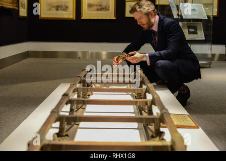 London, Großbritannien. 4. Feb 2019. Matthew Haley, Leiter von Büchern, Karten und Handschriften sieht auf einem Schlitten aus der ersten Shackleton Expedition in die Antarktis. Der Schlitten war auf dem 1907-9 British Antarctic ("Nimrod") Expedition von Eric Marshall, einer der vier Männer, mit Shackleton, Jameson Adams, und Frank Wild, der Schlitten März zum Südpol zu verpflichten. Sie hatten versucht, die am 9. Januar 1909 einen neuen Rekord für den äußersten Süden zu verlassen, erreichen innerhalb von 100 geographischen Meilen von der Stange. Schätzung £ 60.000 - 100.000. Credit: Claire Doherty/Alamy leben Nachrichten Stockfoto