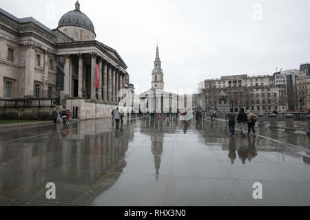 London, Großbritannien. Februar 2019. Regen in London, Großbritannien, heute. National Gallery und St. Martin in the Fields Kirche gesehen spiegelt sich in der nassen Pflasterung der Trafalgar Square Nordterrasse bei Regen heute. Quelle: Joe Kuis/ Alamy Live News Stockfoto