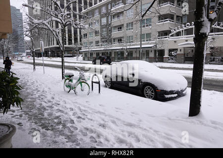 Bellevue, WA, USA. 4 Feb, 2019. Ein Auto und Kalk vermietung Bike im Schnee Stockfoto