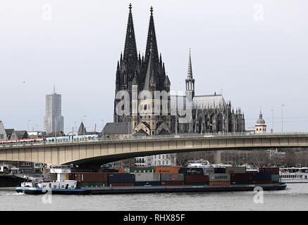 04. Februar 2019, Nordrhein-Westfalen, Köln: Ein binnenschiff ist die Container über den Rhein vor der Kathedrale. Auf einer Pressekonferenz am 05.02.2019, die Generaldirektion für Wasserstraßen und Schifffahrt kommentierte die dauerhaft niedrigen Wasserstand im Jahre 2018, die Reduktion von Emissionen und Infrastruktur Maßnahmen am Rhein. Foto: Oliver Berg/dpa Stockfoto