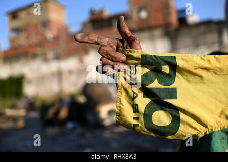 03. Februar 2019, Brasilien, Rio de Janeiro: Everton, 72, zeigt seinen Finger, während Sie ein T-Shirt mit den Worten "Rio" und "Brasil" in der Hand. Everton hat in der Karneval die Vorbereitungen für 28 Jahre miteinbezogen worden. Jetzt lebt er in die armen Viertel der Barrerira tun, Vasco, wo die Zahlen der Karneval Karren der Alegrida da Zona Sul samba Schule gehalten wurden. Die Zahlen sind durch einen Mangel an finanziellen Quellen und recycelt werden und teilweise im Jahr 2019 verwendet. Alegrida da Zona Sul ist die Samba Schule von der Copacabana entfernt. Karneval in Rio 2019 Anfang März. Foto: Fabio Teixei Stockfoto