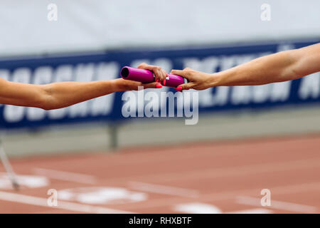 Staffellauf racing Hände Frauen Läufer Weitergabe von Baton Stockfoto