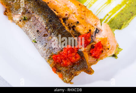 Teil der gebackene Forellenfilet mit Guacamole und Tomatensauce. Stockfoto