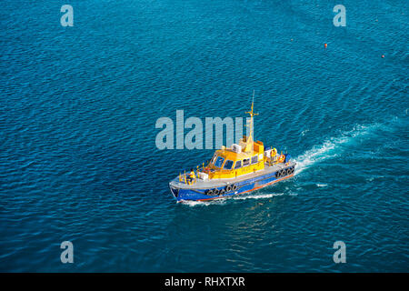 Bridgetown, Barbados - Dezember 12, 2015: Pilot Bereitschaftsboot float im blauen Meer. Maritime Piloten Transport und Verkehr für die Menschen retten. Orange Rettung Boot auf dem Wasser. Boot fließt Menschen zu retten. Stockfoto