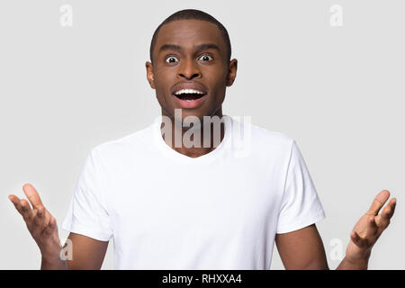 Erstaunt african-american man Gefühl durch Überraschung aufgeregt an Kamera suchen Stockfoto