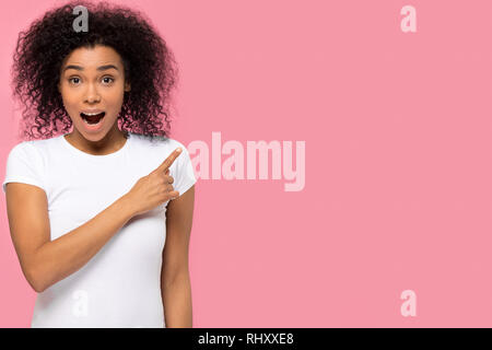 Afrikanische Frau zeigt mit dem Finger auf Copyspace durch Verkauf überrascht überrascht Stockfoto