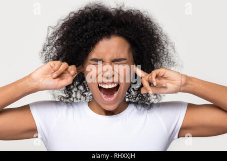 Hartnäckige böse schwarze Frau kleben die Finger in die Ohren stecken Stockfoto