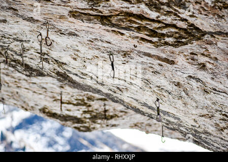 Klettern Expressschlingen in einem Felsen in den italienischen Dolomiten hängen. Stockfoto