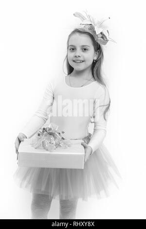 Vorhanden oder Geschenk geben. Mädchen ballerina Lächeln mit Box im rosa Tutu Rock. Urlaub, Geburtstag, Jubiläum. Boxing Day Konzept. Kind mit Blume im langen blonden Haare isoliert auf Weiss. Stockfoto