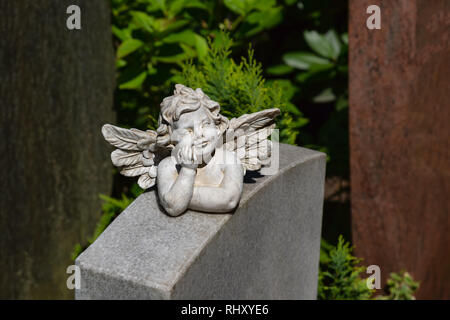 Engel Figur unterstützt das Kinn mit seiner Hand und liegt auf einem Marmor Stein Stockfoto