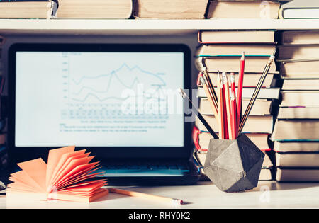 Laptop, Stapel Bücher, Hefte und Stifte auf weißer Tisch, Bildung Büro Konzept Hintergrund Stockfoto