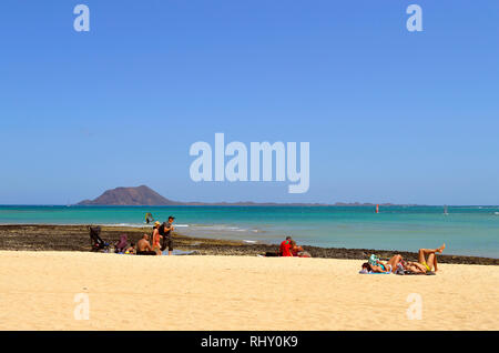 Touristen genießen die Sonne am Strand von Corralejo auf Fuerteventura, eine der Kanarischen Inseln Stockfoto