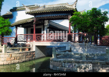 Eine überdachte Brücke über einem Wasser Kanal innerhalb der Luzhi antike Stadt landschaftlich reizvollen Gegend an einem sonnigen Tag in Wuzhong China. Stockfoto