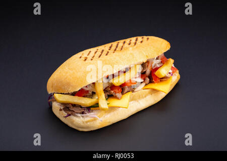 Ciabatta Brot gefüllt mit Käse, Fleisch und Gemüse auf dunklem Hintergrund, selektiver Fokus und Leerzeichen Stockfoto