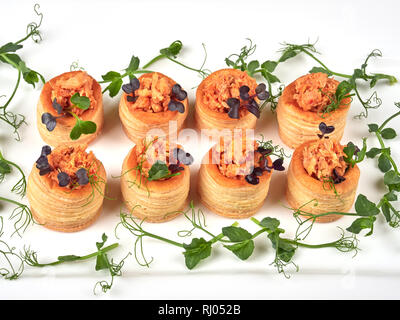 Blätterteiggebäcke mit einem würzigen, chunky Lachs Füllung, garniert mit Erbse Eintragfäden Stockfoto