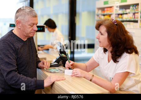Patienten sprechen, Apotheker in der Apotheke Stockfoto
