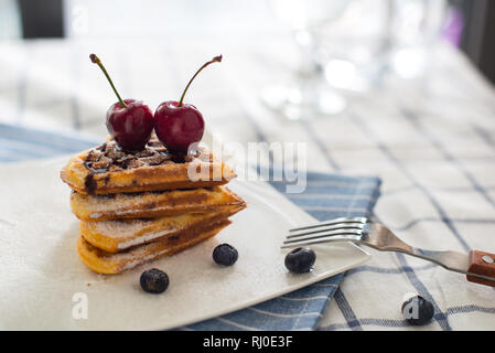 Belgische Waffeln mit Beeren, Torte mit Himbeeren und Cherry Pie auf dem Tisch Stockfoto