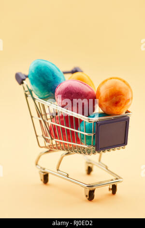 Bunte Ostereier im Warenkorb im Supermarkt vor Ostern Stockfoto