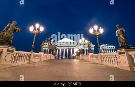 Skopje, Mazedonien - Das archäologische Museum von Mazedonien und die Brücke der Kulturen in der Nacht. Schönes Licht Stockfoto