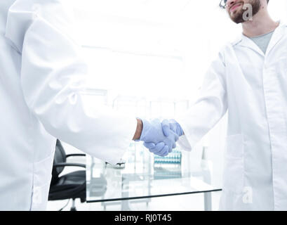 Hand in den medizinischen Handschuh (Handshake). Stockfoto