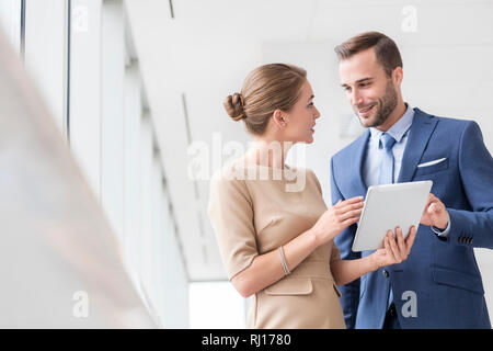 Selbstbewussten jungen Kollegen diskutieren über digitale Tablet im neuen Büro Stockfoto