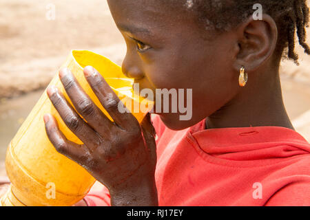 La-toden Dorf, yako Provinz, Burkina Faso. Women's kleine Haushalt Garten und in der Nähe ihrer Häuser. Die Brunnen sind hier tiefer und Nicht trocken laufen. Kinder nehmen einen Drink gut Wasser in der Mittagshitze. Stockfoto