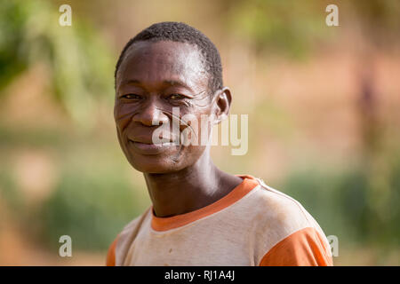 Samba Dorf, yako Provinz, Burkina Faso: Porträts von Denis Zoundi, 45, mit Tribal Narben, während die Bewässerung pflanzen auf seinem Markt Garten. Stockfoto