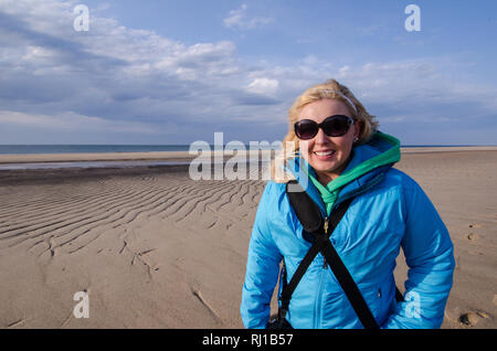 Frau winter Jacke und Zahnrad am Strand von Cape Cod National Seashore im Frühjahr auf Race Point Stockfoto