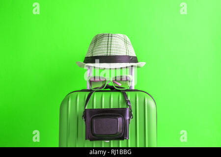 Koffer mit Hut und retro Kamera auf neon grün Hintergrund. Travel Ausrüstung minimal kreatives Konzept. Stockfoto