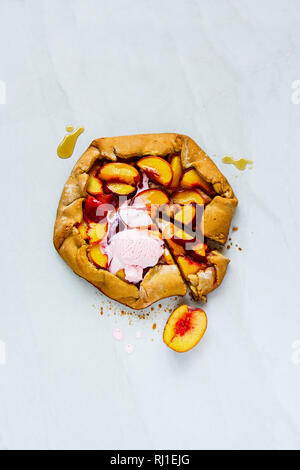 Flachbild-lay von Pfirsich Galette süße Kuchen mit Eiscreme. Saisonale Fallen oder im Herbst Dessert Stockfoto