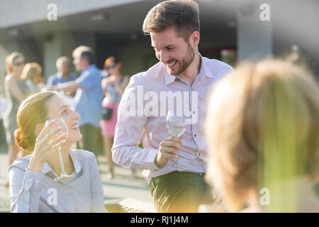Gerne Kollegen sprechen während der Erfolg Party auf der Terrasse Stockfoto