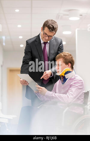 Doktor, erklären, Dokument für behinderte Patienten im Rollstuhl im Krankenhaus Stockfoto