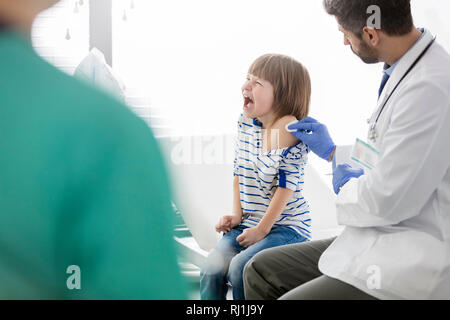 Arzt impfen schreienden Jungen im Krankenhaus Stockfoto