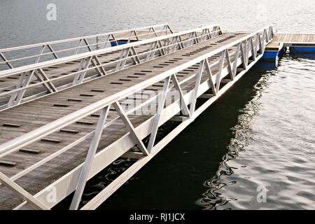 Moderne Holzsteg oder Pier mit Metall Seiten ohne Menschen oder Boote. Boot Rampe und Pier Stockfoto