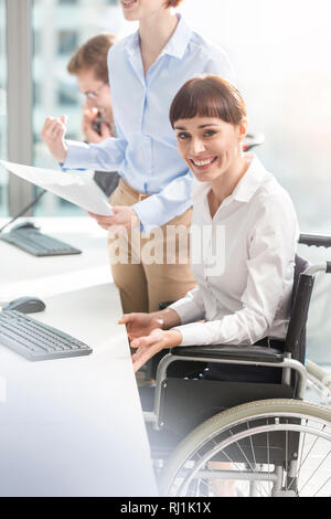 Portrait von lächelnden behinderten Geschäftsfrau Arbeiten von Kollegen in modernen Büro Stockfoto