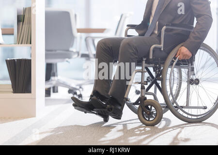 Low Angle View von behinderten Geschäftsmann auf Rollstuhl im modernen Büro Stockfoto