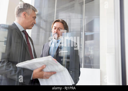 Reife Unternehmer diskutieren über Dokument im neuen Büro Stockfoto