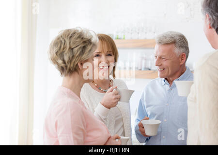 Gerne reif Freunde halten Getränke beim Gespräch im Wohnzimmer zu Hause Stockfoto