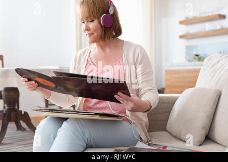 Reife Frau auf aufzeichnen, während der Wiedergabe von Musik im Wohnzimmer Stockfoto