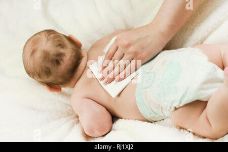 Ein neugeborenes Baby Windel ändern: die Mutter wischt das Baby mit einem Baby abwischen. Das Konzept der Sauberkeit und Pflege Stockfoto